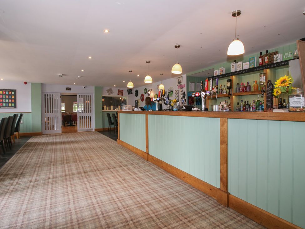A bar area with stools and a counter at Keepers Cottage in Shobdon