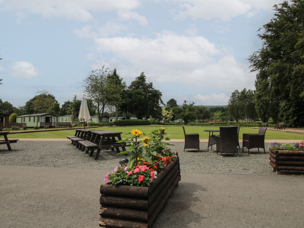 An outdoor space with tables and flowers at Keepers Cottage in Shobdon