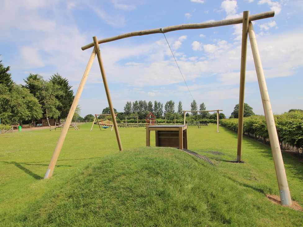 A playground with swings and a slide at Keepers Cottage in Shobdon