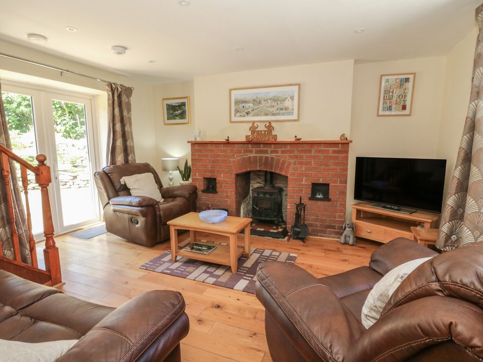 A living room with a fireplace and sofa at Felin Gogoyan Tregaron