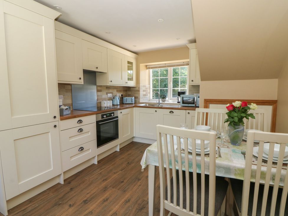 A kitchen with cabinets and a dining area at Felin Gogoyan Tregaron
