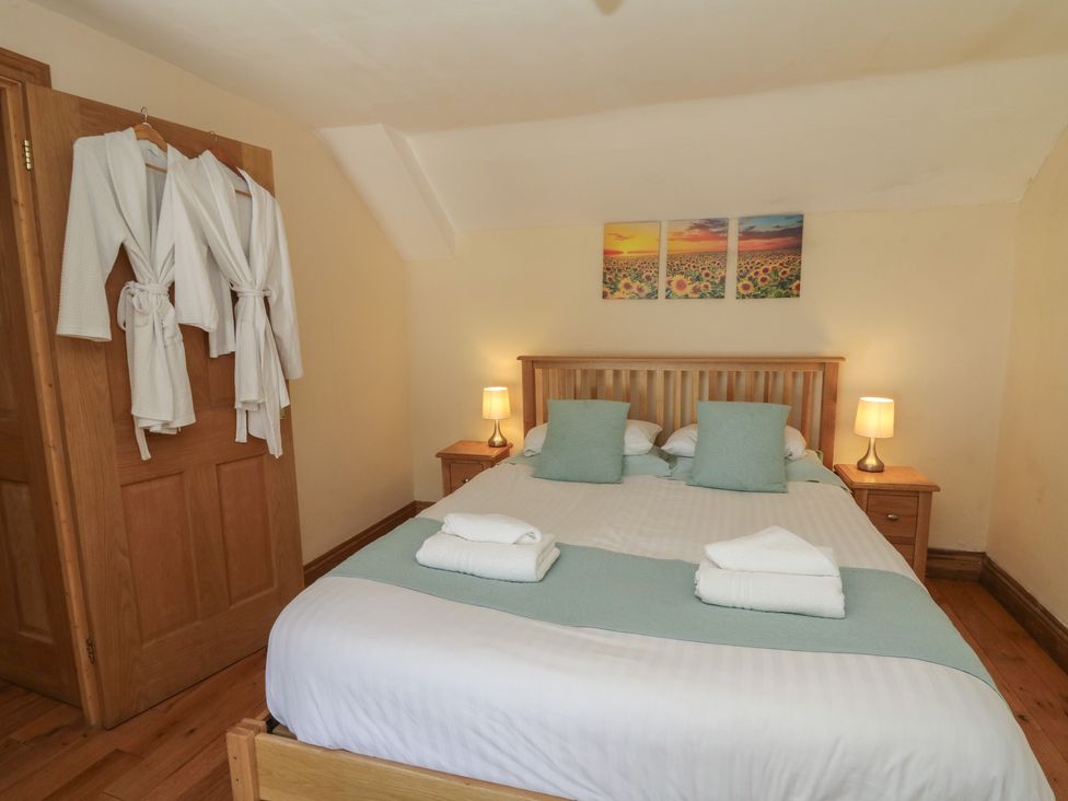 A bedroom with a bed and bedside table at Felin Gogoyan in Tregaron