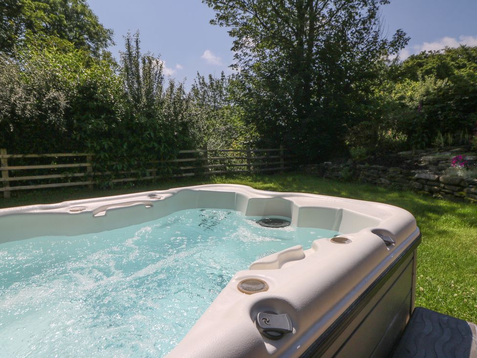 A hot tub with water in a garden at Felin Gogoyan Tregaron
