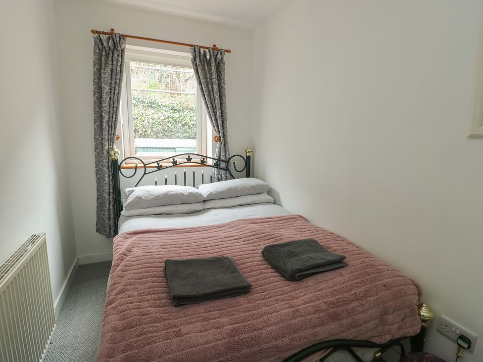 A bedroom with a bed and towels at 23 Beach Road Y Felinheli