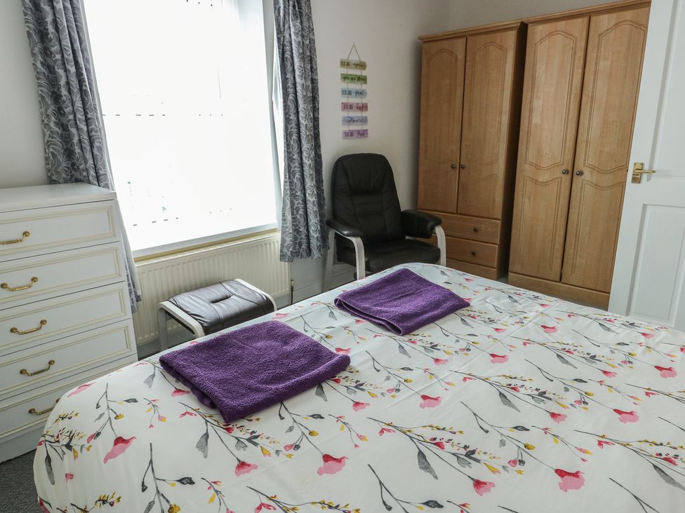 A bedroom with a bed and wardrobe at 23 Beach Road in Y Felinheli