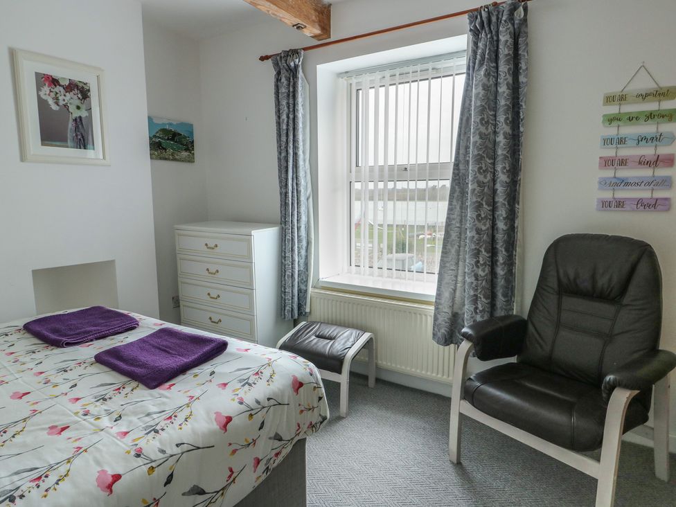 A bedroom with a bed and towels on it at 23 Beach Road in Y Felinheli