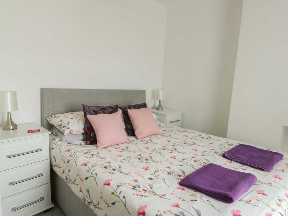A bedroom with a bed and bedside tables at 23 Beach Road in Y Felinheli