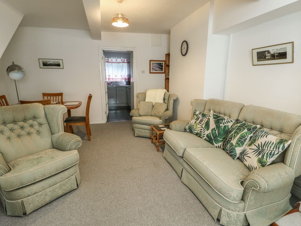 A living room with a sofa and armchair at 23 Beach Road Y Felinheli