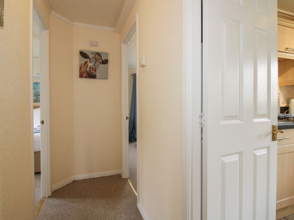 A hallway with a painting and doors at Snowdrop in Eardisland