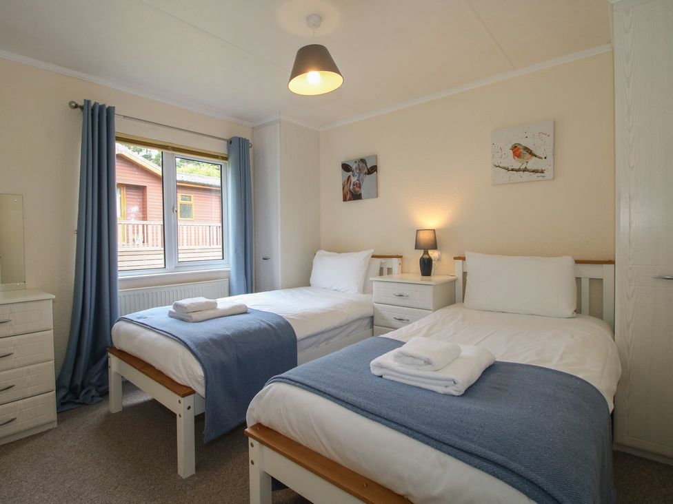 A bedroom with two beds and a window at Snowdrop in Eardisland