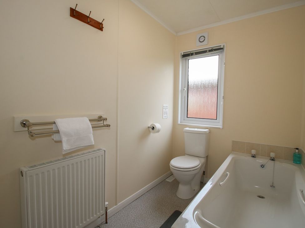 A bathroom with a bathtub and toilet at Snowdrop in Eardisland