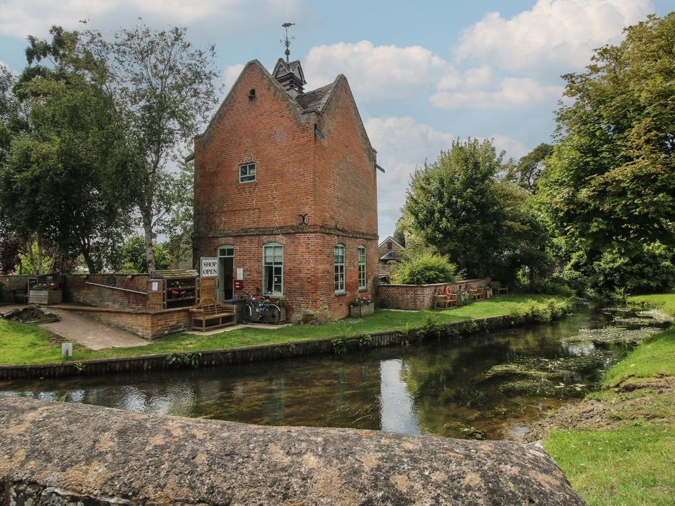 A building near a canal with a shop sign and bicycles at Snowdrop in Eardisland
