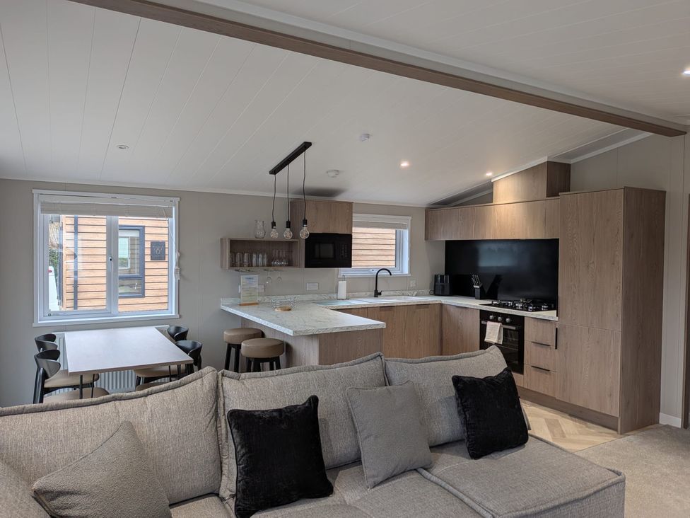 A kitchen with an island and sofa at Snowdrop in Eardisland