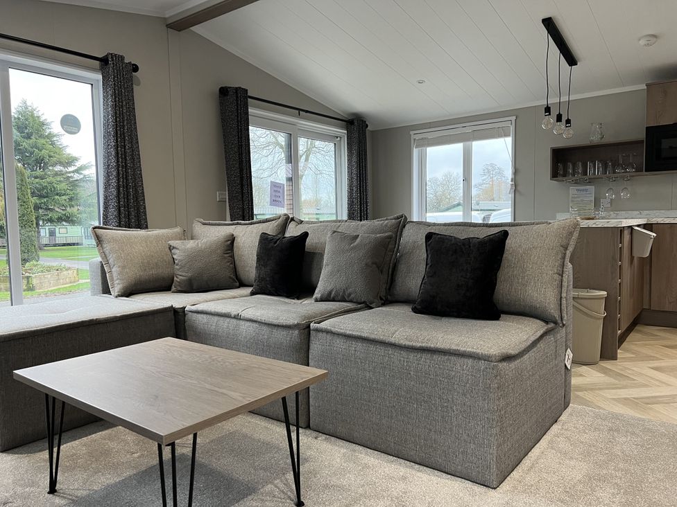 A living room with a sectional sofa and coffee table at Snowdrop in Eardisland