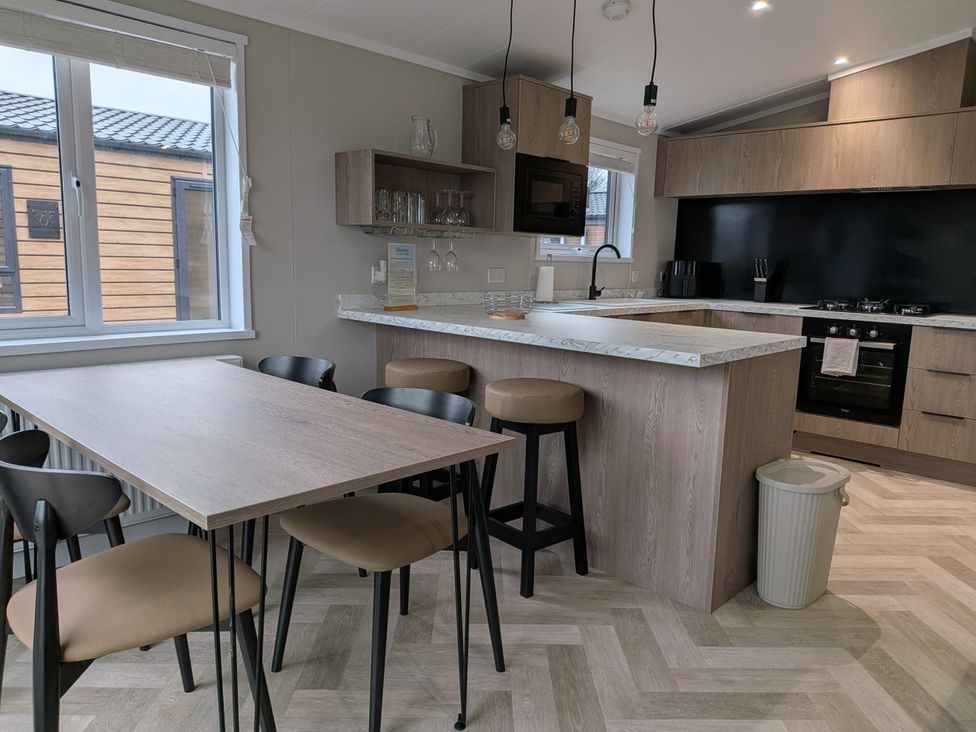 A kitchen with a dining table and chairs at Snowdrop in Eardisland