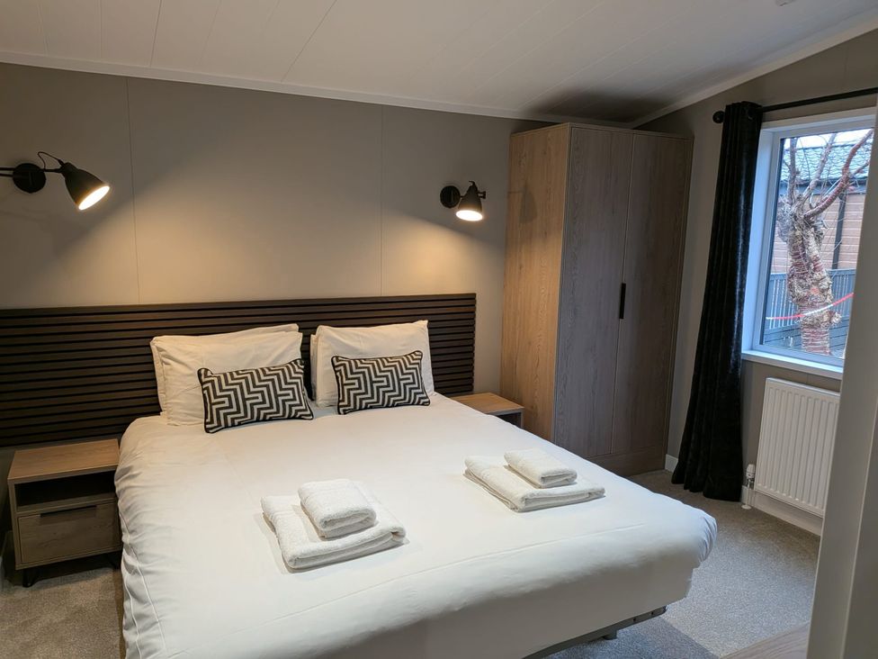 A bedroom with a bed and wardrobe at Snowdrop in Eardisland