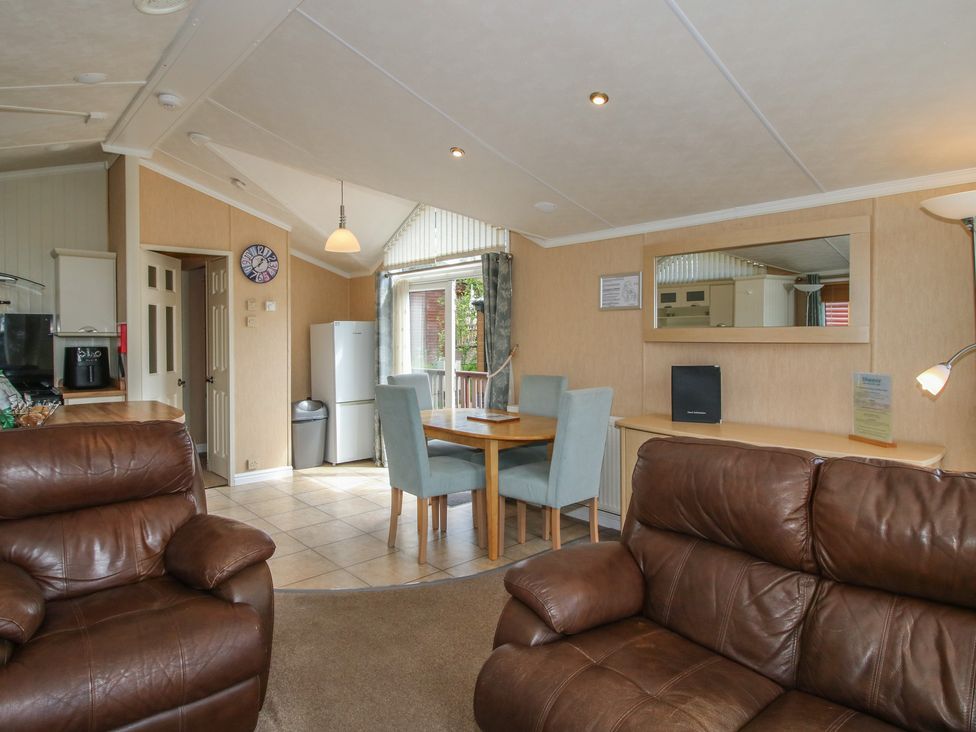 A living room with dining table and refrigerator at Daisy in Eardisland