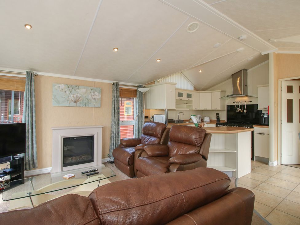 A living room with a fireplace and sofa at Daisy in Eardisland