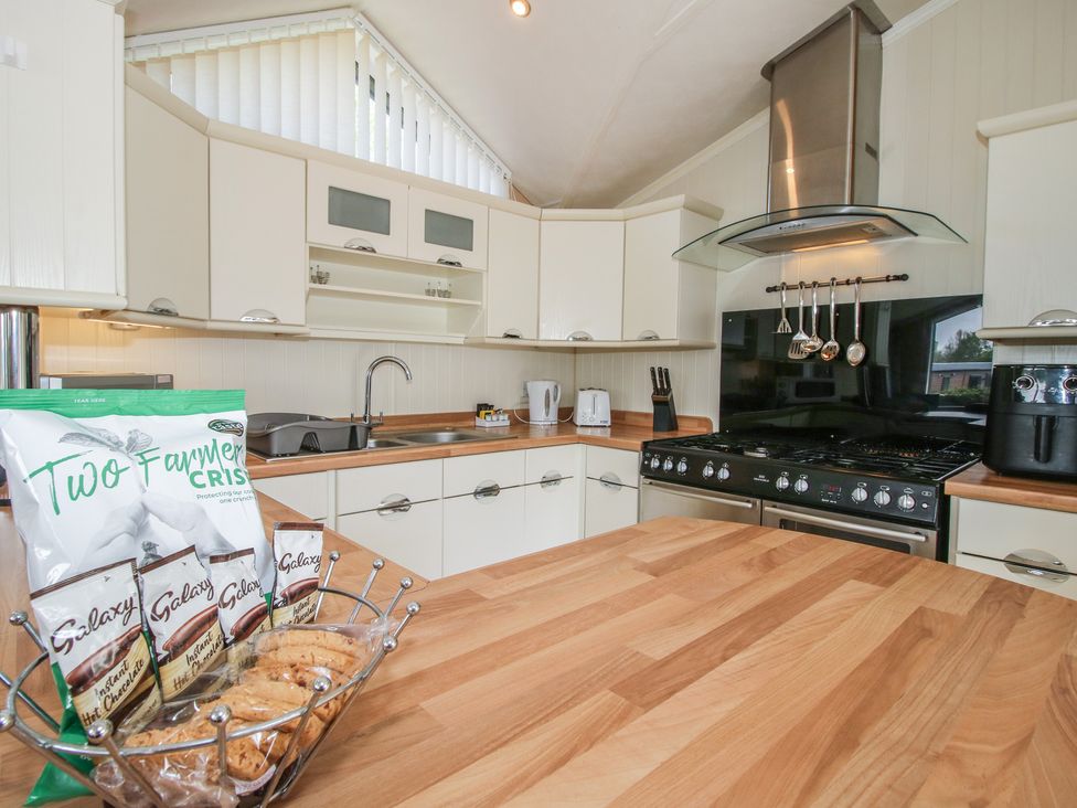 A kitchen with a wooden island and kitchen appliances at Daisy in Eardisland