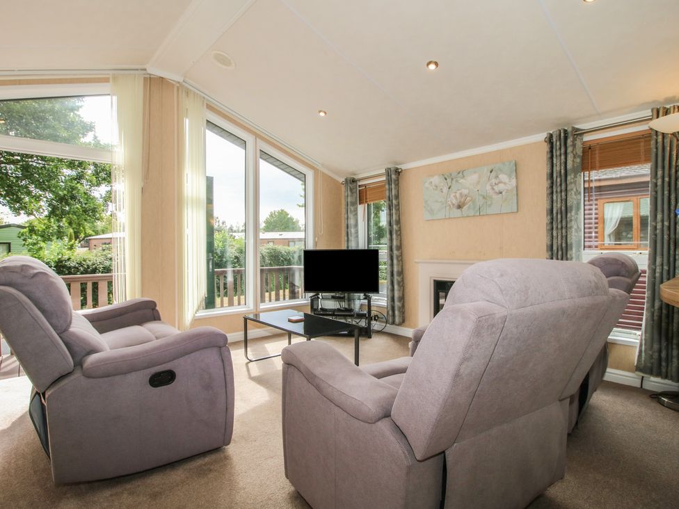 A living room with recliner chairs and a television at Daisy in Eardisland