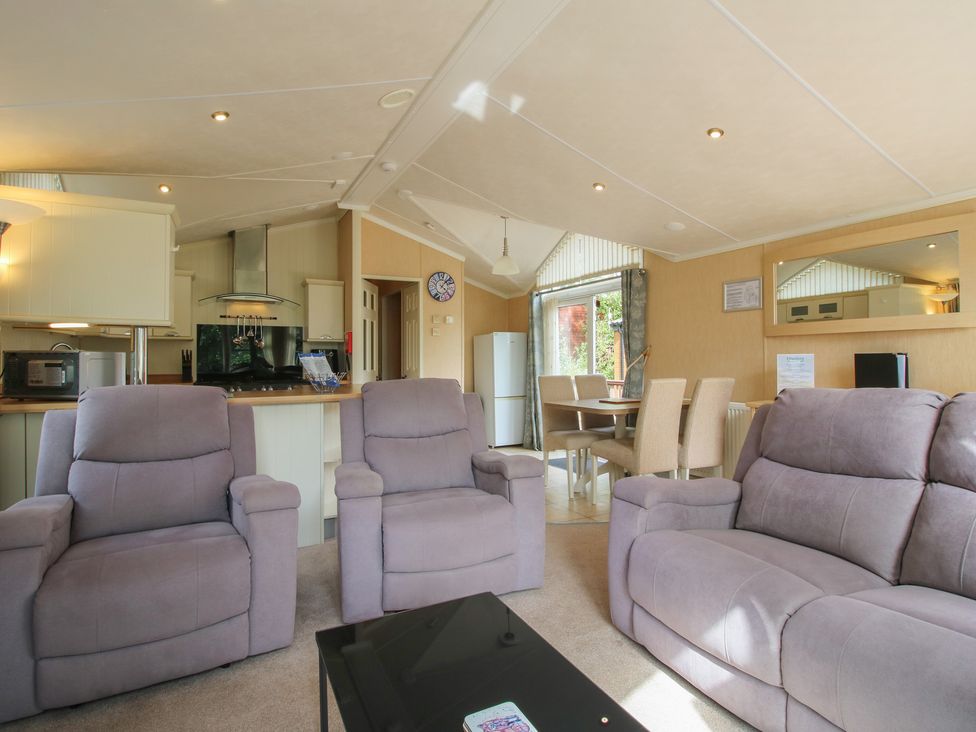 A living room with sofa and dining area at Daisy in Eardisland