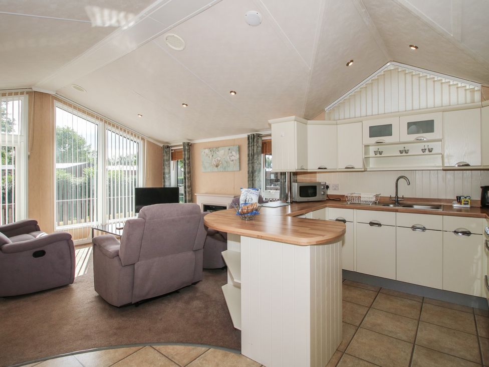 A living room with a kitchen area at Daisy in Eardisland