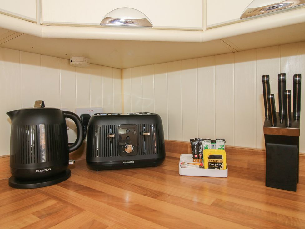 A kitchen area with a kettle toaster and knife block at Daisy in Eardisland