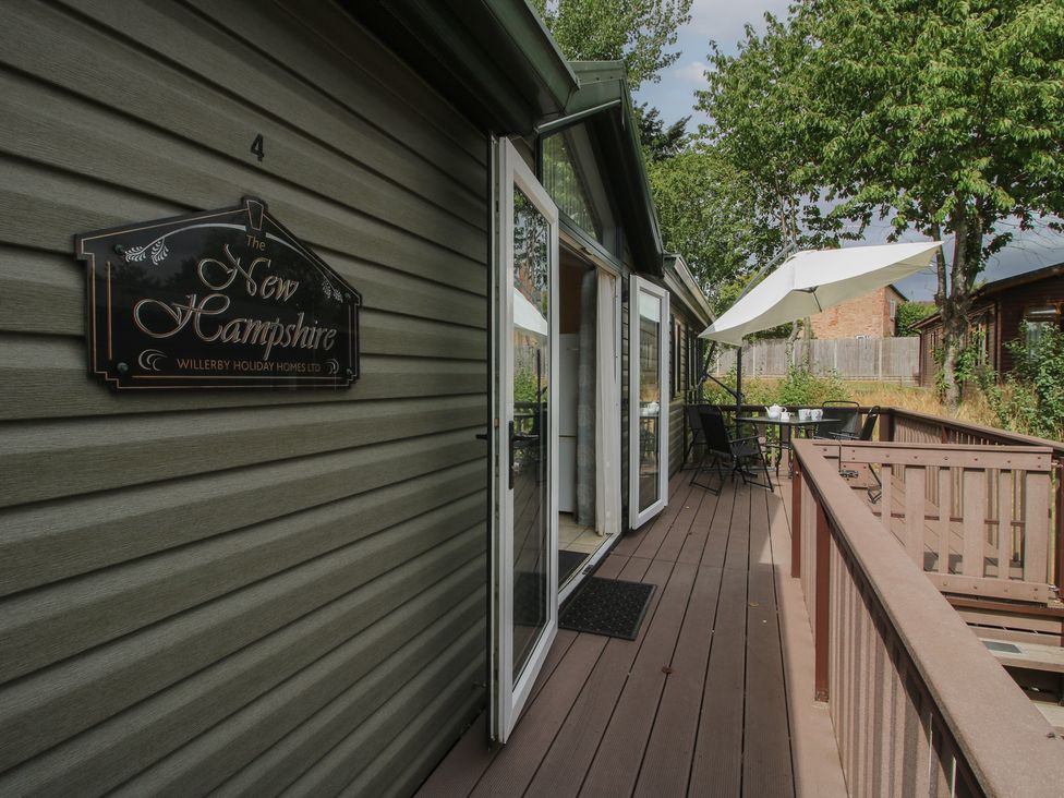 A deck with an umbrella and chairs at The New Hampshire in Eardisland