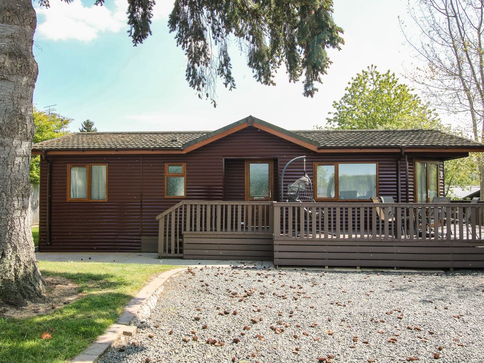 A house with a deck and swing in front at Foxglove Eardisland