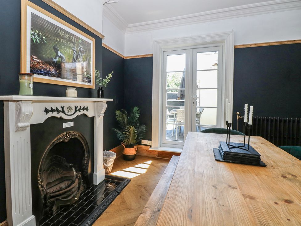 A dining room with a table and fireplace at Sunrise House in Pakefield near Lowestoft