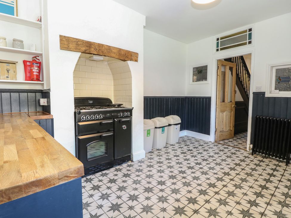 A kitchen with a cooker and recycling bins at Sunrise House in Pakefield near Lowestoft