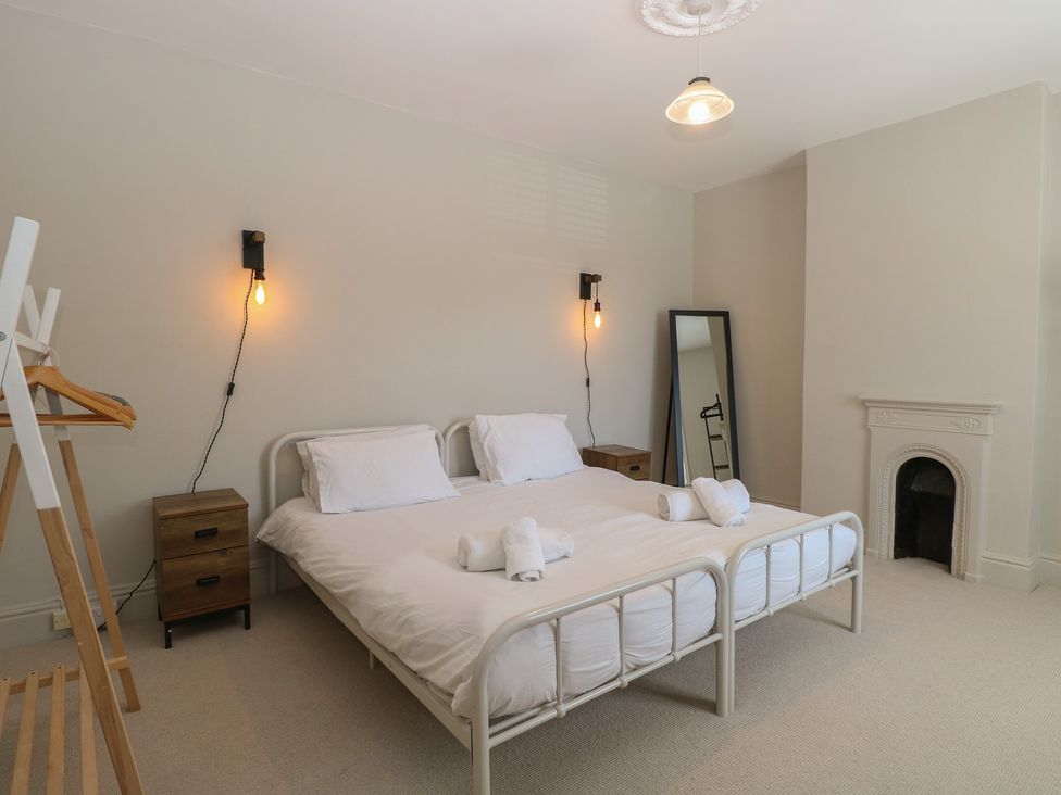 A bedroom with a bed and a mirror at Sunrise House in Pakefield near Lowestoft