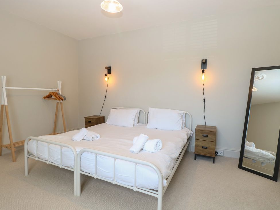A bedroom with a bed and a clothes rack at Sunrise House in Pakefield near Lowestoft
