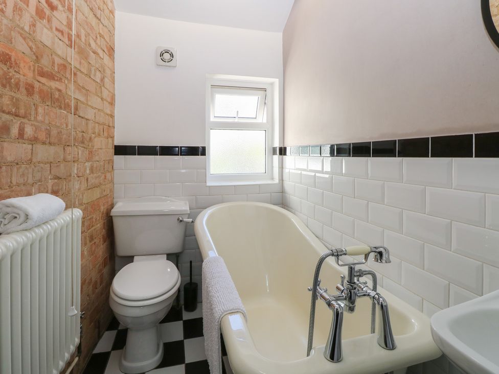 A bathroom with a bathtub and toilet at Sunrise House Pakefield near Lowestoft