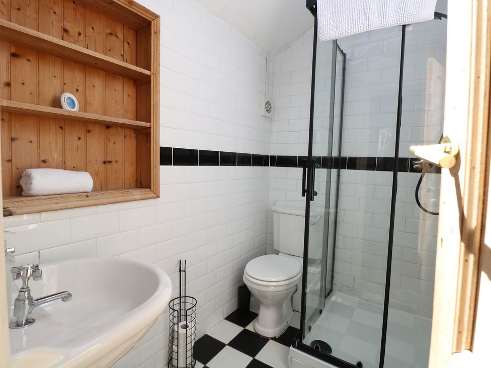 A bathroom with a sink, toilet, and shower at Sunrise House in Pakefield near Lowestoft