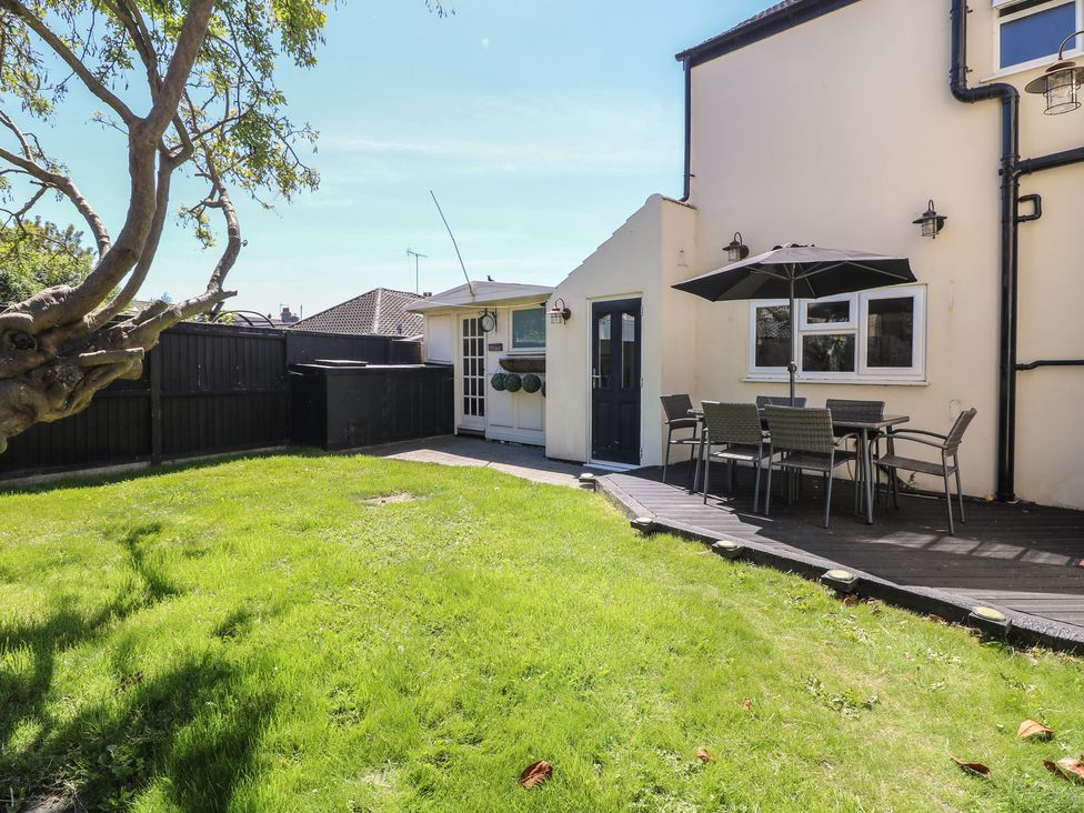 A garden with a patio and dining area at Sunrise House in Pakefield near Lowestoft
