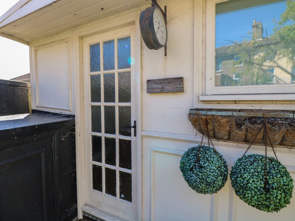 An outdoor entrance with a clock and plants at Sunrise House Pakefield near Lowestoft