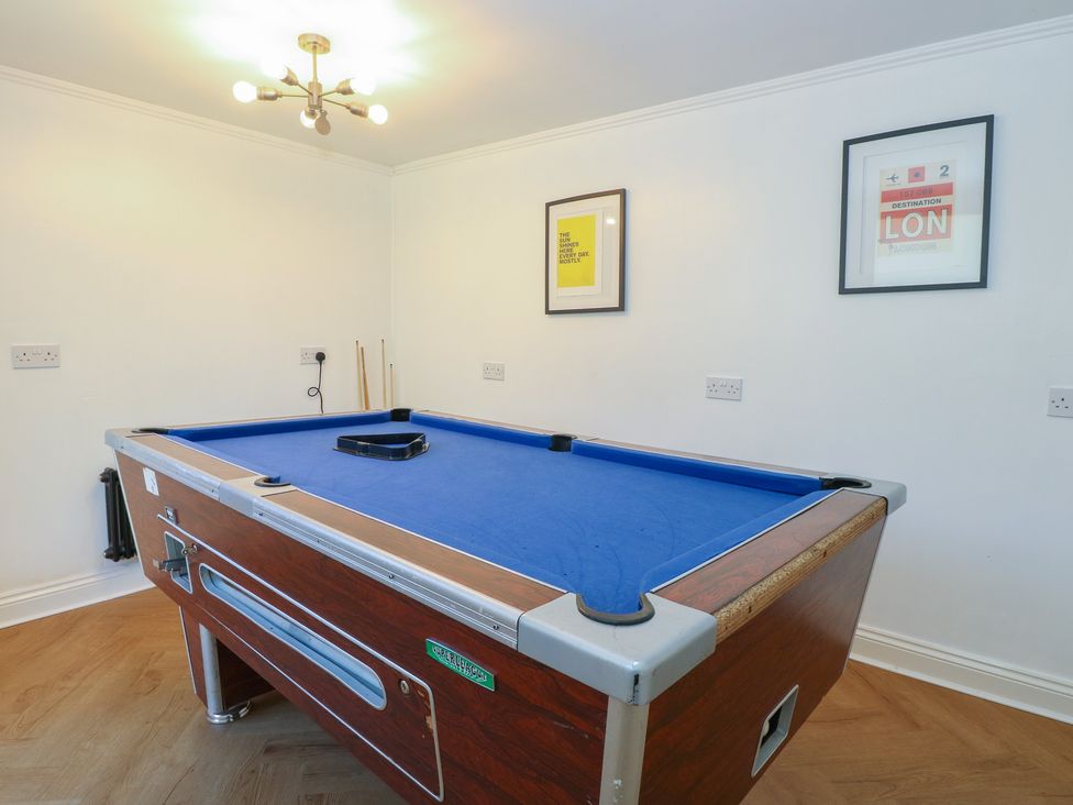 A game room with a pool table and wall art at Sunrise House in Pakefield near Lowestoft