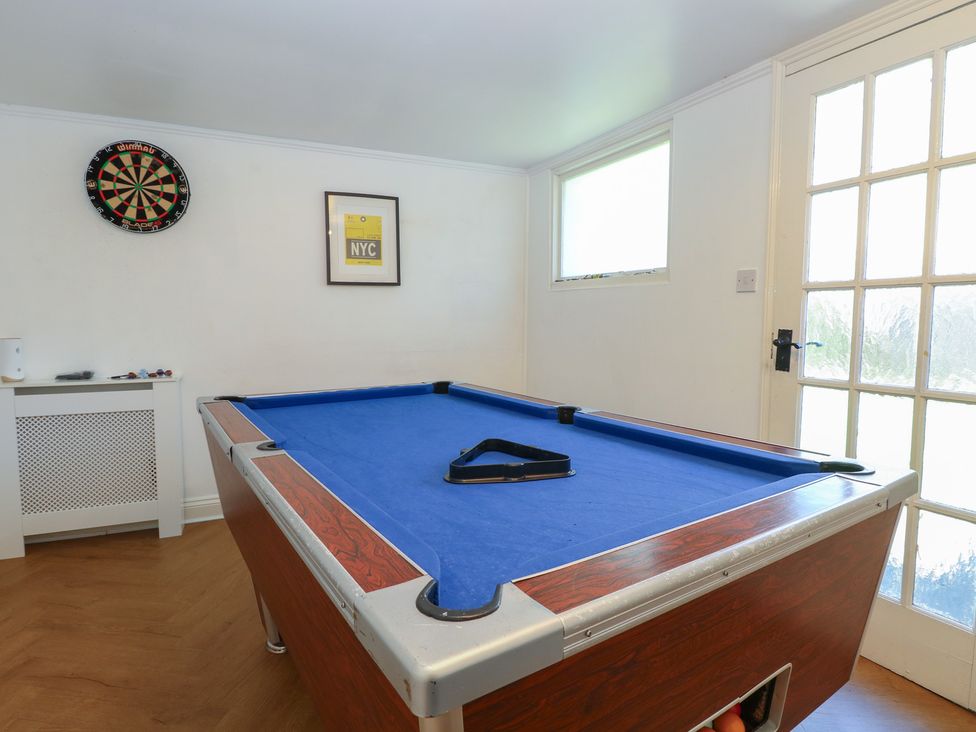 A game room with a pool table and dartboard at Sunrise House in Pakefield near Lowestoft