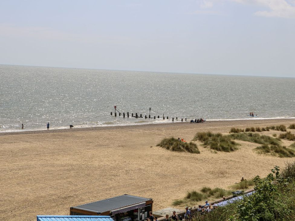 A beach with groynes and people at Sunrise House in Pakefield near Lowestoft