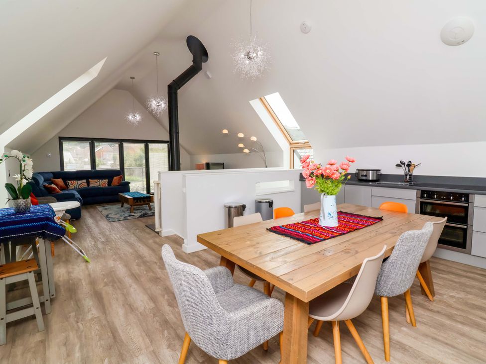 A living room with a dining table and sofa at Pebble Ridge View in Westward Ho!