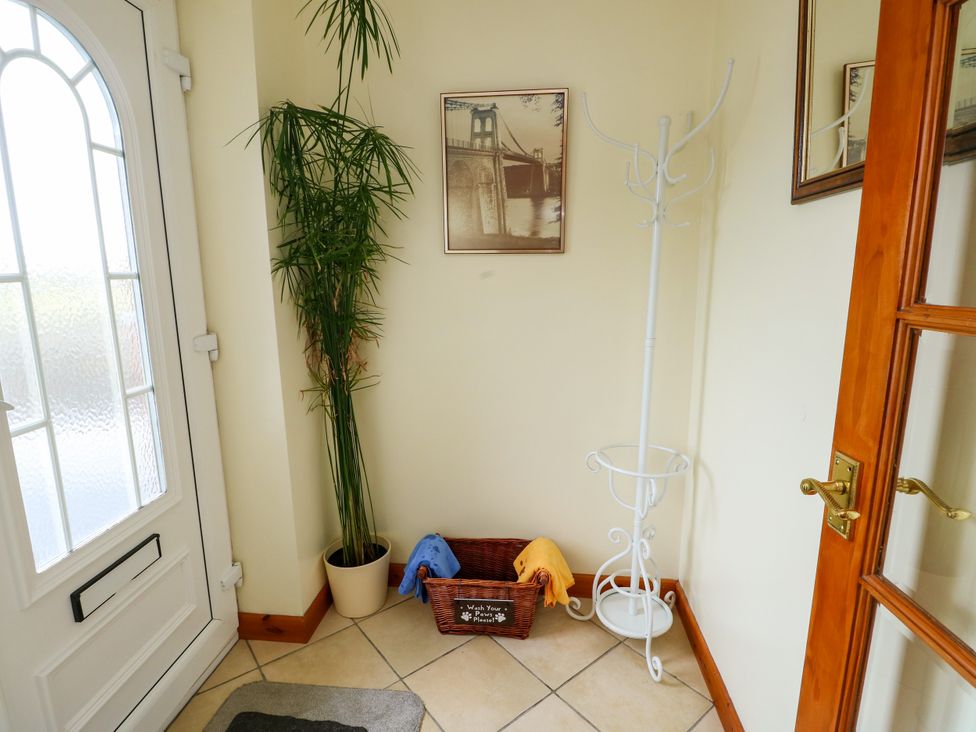 A hallway with a plant and coat rack at The Cottage at Ty Newydd in Brynsiencyn