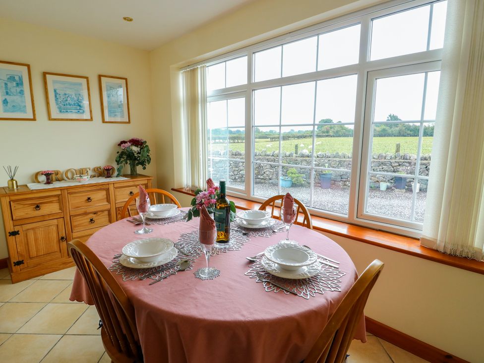 A dining room with a table set for dinner at The Cottage at Ty Newydd in Brynsiencyn