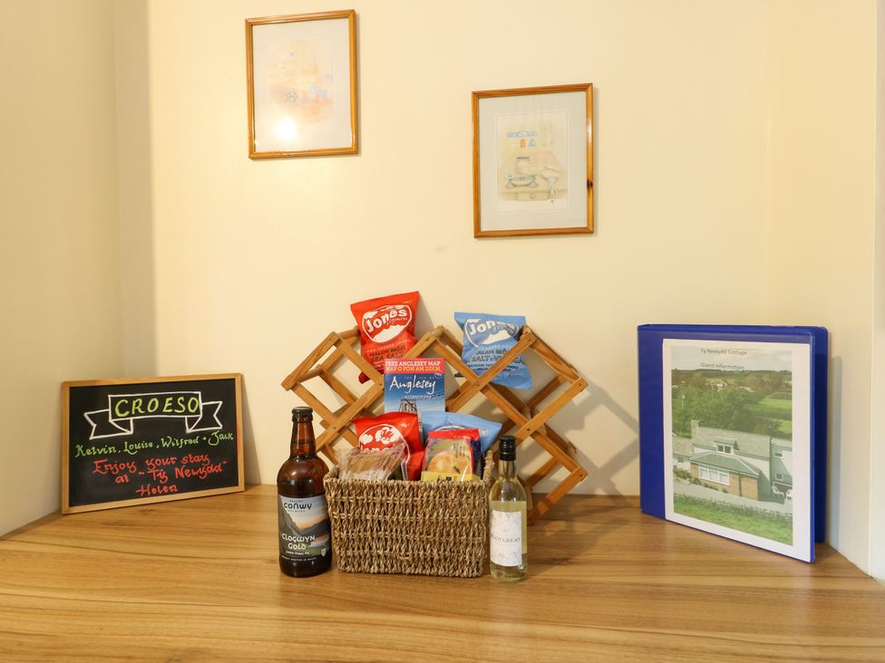A kitchen countertop with snacks and a welcome sign at The Cottage at Ty Newydd Brynsiencyn