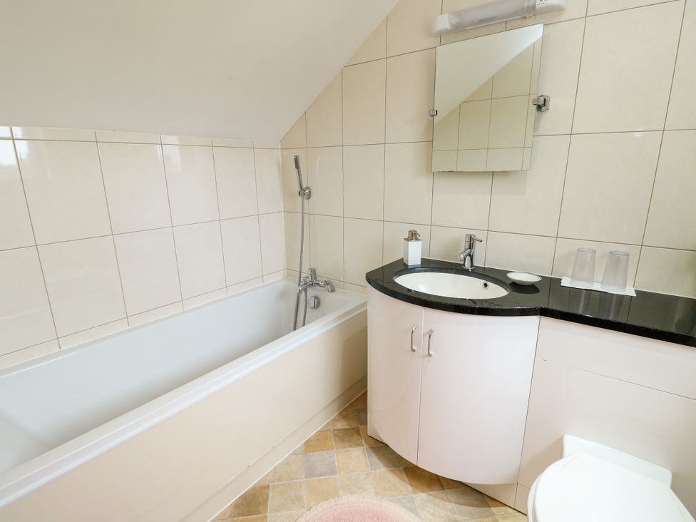 A bathroom with a bathtub and sink at The Cottage at Ty Newydd in Brynsiencyn