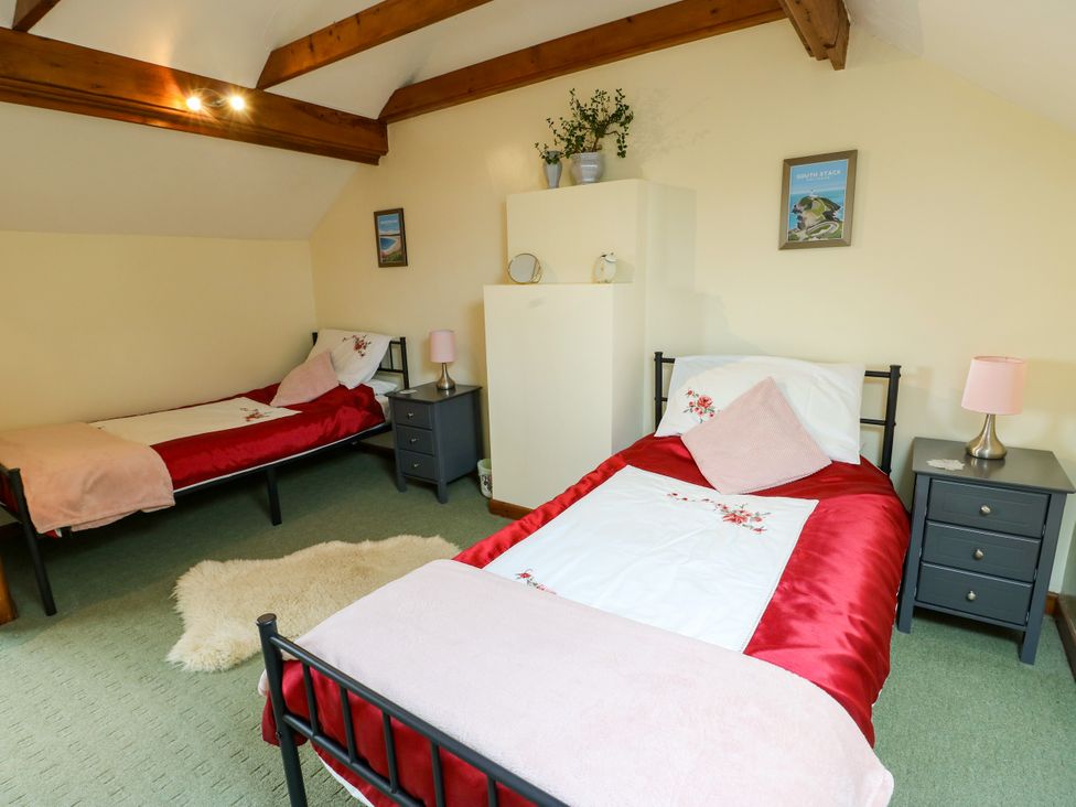 A bedroom with two beds and nightstands at The Cottage at Ty Newydd in Brynsiencyn