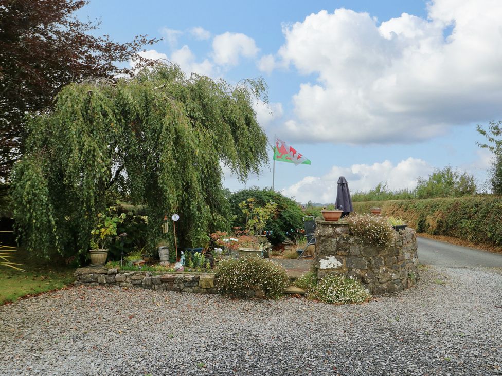 An outdoor area with gravel driveway and plants at The Cottage at Ty Newydd in Brynsiencyn