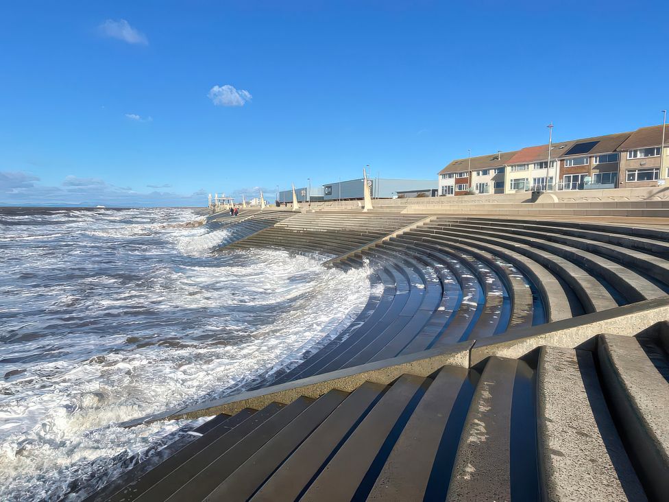 A beach with step seating and buildings near the water at 26 North Promenade in Cleveleys
