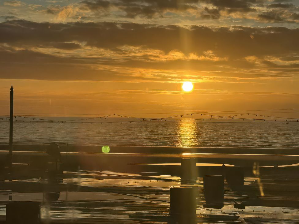 A sunset over the ocean with poles and lighting at 26 North Promenade Cleveleys
