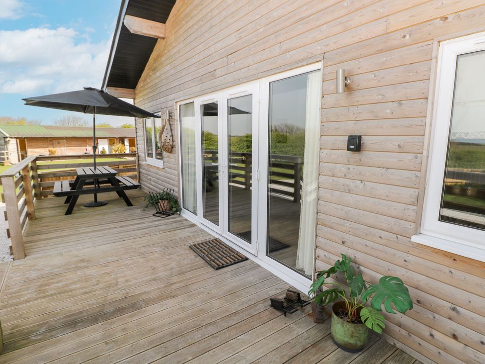 An outdoor area with a table and umbrella at Monks Rest in Monknash